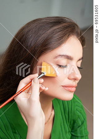 Make up artist applying professional make up of tonal foundation 69531605