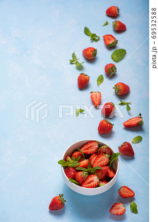 mint and ripe strawberries in a white bowl 69532588