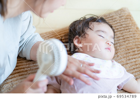 真夏　寝ている赤ちゃんにハンディ扇風機を当てる母の手 69534789