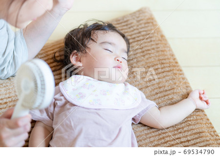真夏 寝ている赤ちゃんにハンディ扇風機を当てる母の手 真夏 寝ている赤ちゃんにハンディ扇風機を当てる母の手 69534790