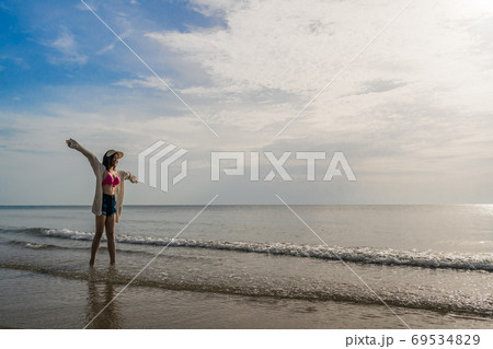 freedom woman in bikini walking with arms raised on sea beach 69534829