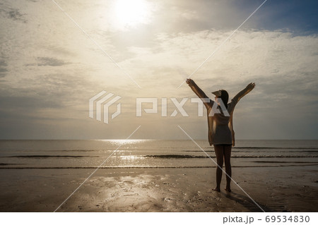 freedom woman in bikini walking with arms raised on sea beach 69534830