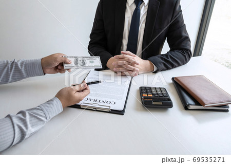 Businessman giving bribe money in the envelope of Businessman giving bribe money in the envelope of 69535271