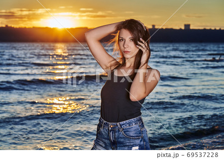 A young brunette woman in a black undershirt A young brunette woman in a black undershirt 69537228