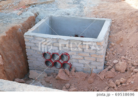 SEREMBAN, MALAYSIA -AUGUST 5, 2020: Utility services manhole and underground pipes under construction at the construction site. In-situ construction by workers based on infrastructure engineer design. SEREMBAN, MALAYSIA -AUGUST 5, 2020: Utility services manhole and underground pipes under construction at the construction site. In-situ construction by workers based on infrastructure engineer design. 69538696
