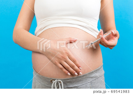 Close up of pregnant woman making injection of insulin in her be Close up of pregnant woman making injection of insulin in her be 69541983