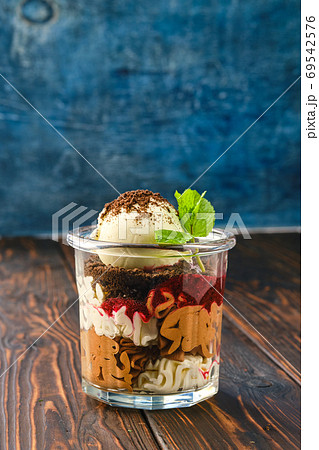 Dessert with cookie crumbs, soft cheese and ice cream with grated chocolate Dessert with cookie crumbs, soft cheese and ice cream with grated chocolate 69542576