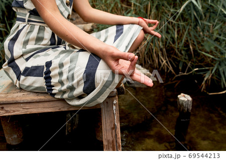 Young woman in dress meditating on the nature Young woman in dress meditating on the nature 69544213