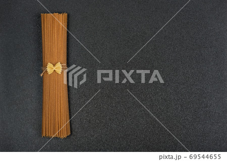 Organic spaghetti from whole grain flour. Ingredients of Italian cuisine. Copy space. Template. Mockup. Organic spaghetti from whole grain flour. Ingredients of Italian cuisine. Copy space. Template. Mockup. 69544655