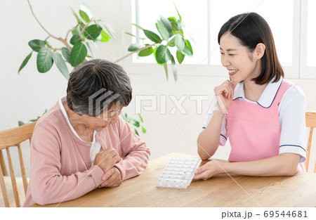 薬ケースの説明をする介護士 69544681