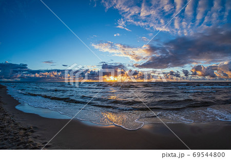 Sandy beach at dusk under a stormy sky. Seascape with waves and Sandy beach at dusk under a stormy sky. Seascape with waves and 69544800