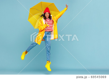Happy ethnic female jumping with umbrella. 69545069