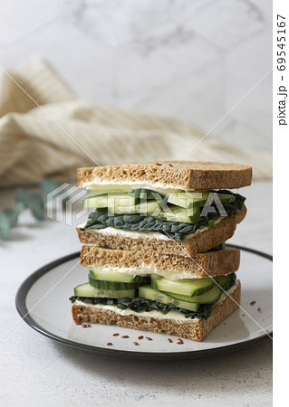 Healthy sandwich with cucumber and kale leaves. Vegan food snack, breakfast. 69545167