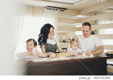 the family makes cakes. the children were covered in flour. dinner at the bakery. feast in the kitchen the family makes cakes. the children were covered in flour. dinner at the bakery. feast in the kitchen 69550160