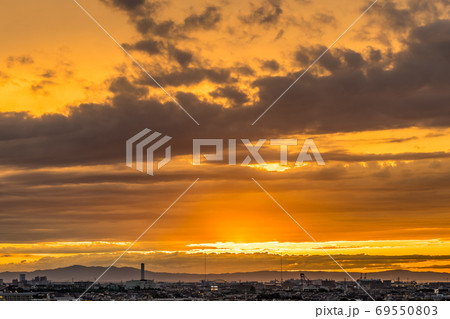 淡路島に沈む夕日と空一面の夕焼けを大阪府堺市から撮影の写真素材