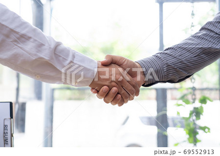 Two confident business man shaking hands during a meeting in the Two confident business man shaking hands during a meeting in the 69552913