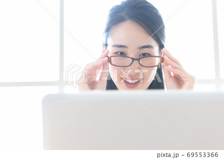 ビジネス　パソコン作業中にブルーライトカットの眼鏡をかける女性 69553366