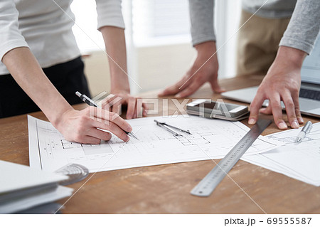 カジュアルなオフィスで打ち合わせをする日本人設計士 69555587