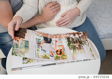 couple waiting for baby flips through photo book couple waiting for baby flips through photo book 69555636