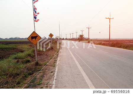 Curve road on countryside with two traffic sign in Thailand. Curve road on countryside with two traffic sign in Thailand. 69556016