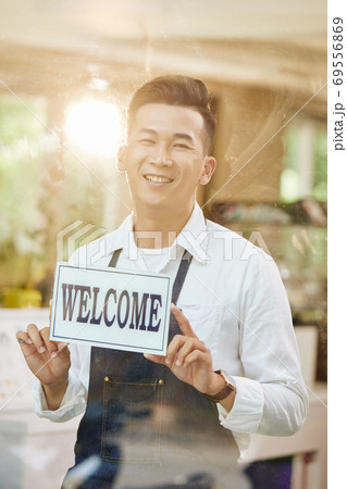 Coffeeshop owner welcoming customers 69556869
