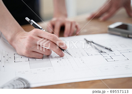 カジュアルなオフィスで打ち合わせをする日本人設計士 69557113