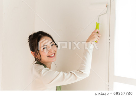 DIYで家の壁にペンキを塗る女性 DIYで家の壁にペンキを塗る女性 69557730