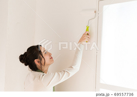 DIYで家の壁にペンキを塗る女性 69557736