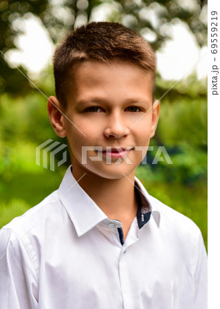 Portrait of a schoolboy in a white shirt near the school 69559219
