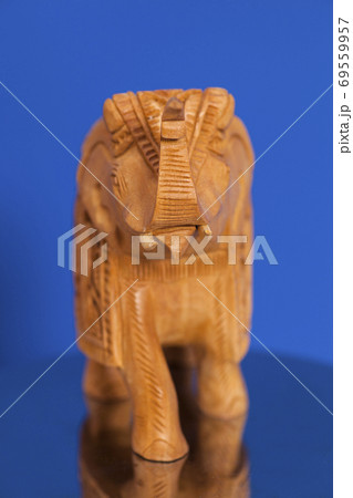 Wooden elephant sculpture on blue background Wooden elephant sculpture on blue background 69559957