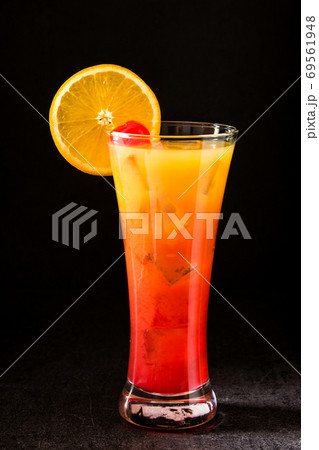 Tequila sunrise cocktail in glass on black background Tequila sunrise cocktail in glass on black background 69561948