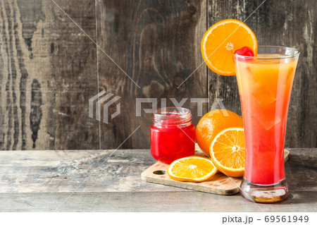 Tequila sunrise cocktail in glass on wooden table. Copyspace Tequila sunrise cocktail in glass on wooden table. Copyspace 69561949