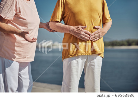 Senior Caucasian man holding his stomach with both hands Senior Caucasian man holding his stomach with both hands 69563936