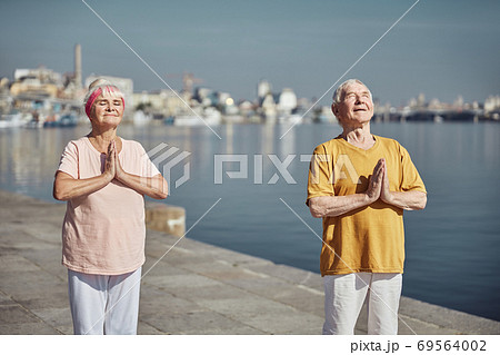 Elderly Caucasian couple performing a yoga exercise 69564002