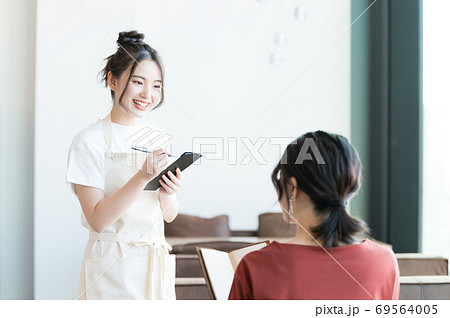 注文を取るカフェの女性スタッフの写真素材