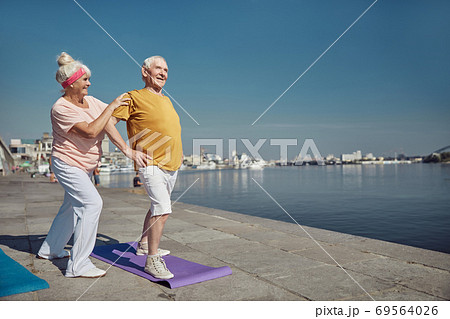 Man performing a warm-up exercise on the quay Man performing a warm-up exercise on the quay 69564026