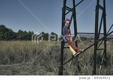 scary evil clown on an abandoned billboard 69564871
