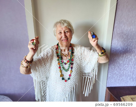 Happy smiling funny senior woman wearing beads dancing 69566209