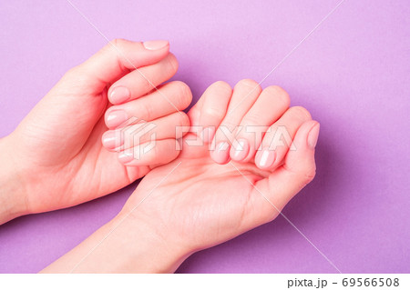 Beautiful female hands showing fresh cute manicure, skin and nail care concept, purple background 69566508