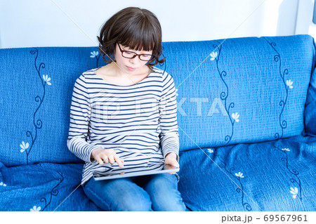 リビングでタブレットPCを操作する女性 リビングでタブレットPCを操作する女性 69567961