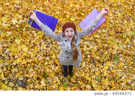 Happy girl in hat holding shopping bags. Autumn sales and discounts. Top view Happy girl in hat holding shopping bags. Autumn sales and discounts. Top view 69568372