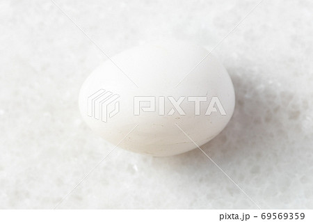 tumbled Milky Quartz rock on white marble tumbled Milky Quartz rock on white marble 69569359