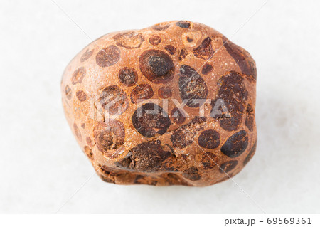 tumbled Bauxite rock on white marble 69569361