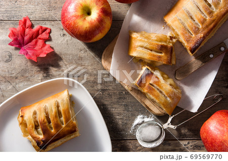 Traditional homemade apple strudel on wooden table Traditional homemade apple strudel on wooden table 69569770