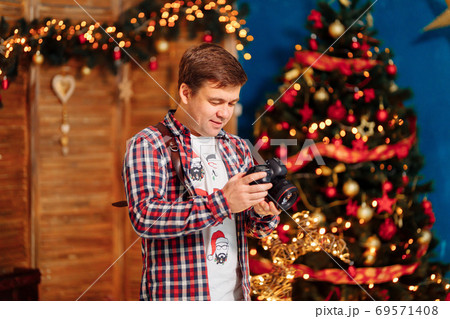 photographer in plaid shirt at Christmas tree. photographer in plaid shirt at Christmas tree. 69571408