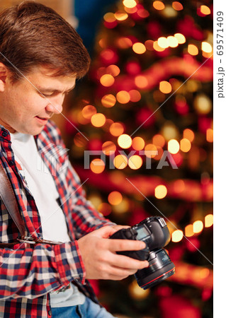 photographer with camera looks at display 69571409