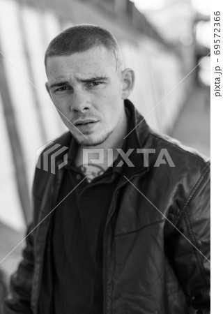 Bully criminal in black leather jacket. Black and white photo Bully criminal in black leather jacket. Black and white photo 69572366
