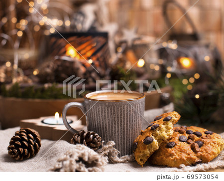 Mug of cocoa with chocolate chip cookies on a wooden table. Christmas drink and biscuit, festive 69573054
