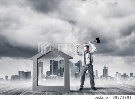 Manager man crashing stone home as symbol for real estate insurance 69573391