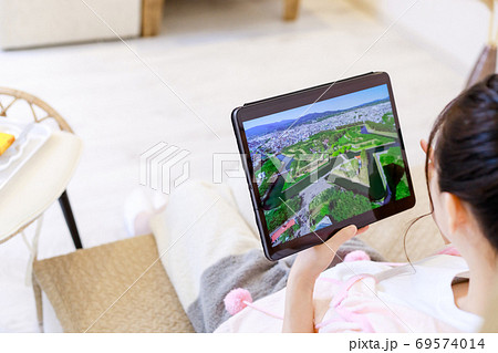 タブレットで旅行先を検索する若い女性 69574014